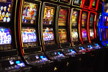 A woman smiling by bright slot machines showing lucky symbols, showcasing the exciting slot offerings at CD444.